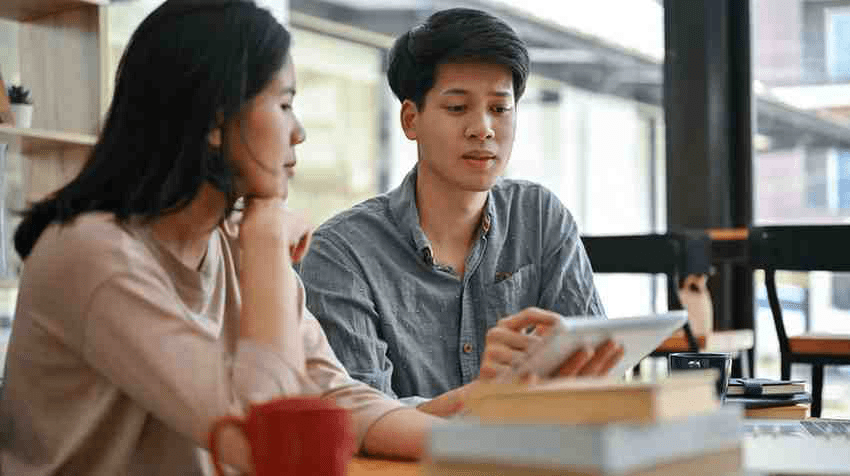 A medical school student and his Step 2 CK tutor studying with a variety of resources in a cafe.